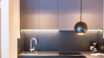 Een koelkast, een kookplaat, kookgerei, borden en bestek