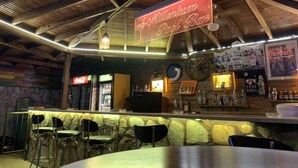 A bar area with a neon sign reading "Millennium Pool Bar," a Coca-Cola refrigerator, and a variety of bottles on shelves. - Tekirova Millennium Hotel (Kemer)