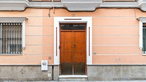 Un edificio con una puerta de madera doble, número 15, y un escalón que conduce a la entrada.