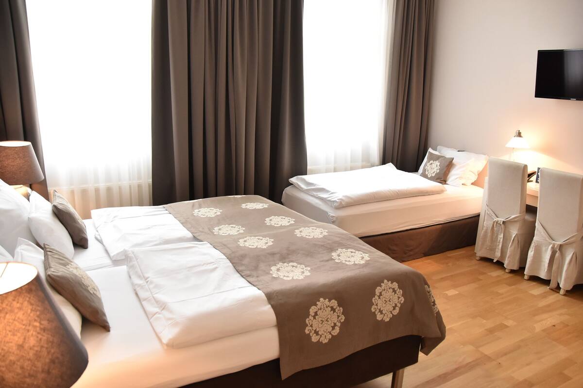 Une chambre d’hôtel avec deux lits, une télévision et une lampe.