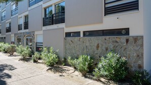 A modern multi-story residential building with balconies, stone facade, and small plants along the walkway. - Le Liberté by Interhome (Saint Cyprien)