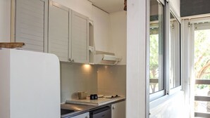 A kitchen with white cabinets, a stainless steel sink, and a dishwasher. - Le Liberté by Interhome (Saint Cyprien)