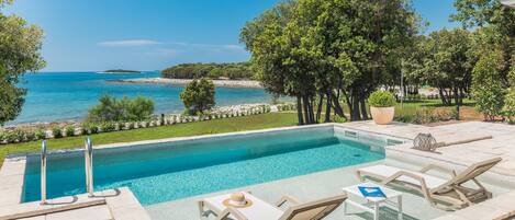 Piscine extérieure, parasols de plage, chaises longues