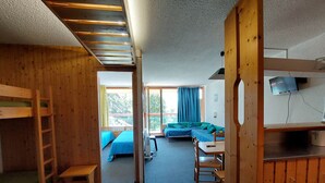Una habitació amb lliteres, escriptori, cadira i televisió.