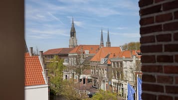 A view of a canal with buildings and a church with two spires.