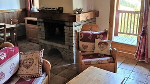 Una habitación acogedora con chimenea de piedra, muebles de madera y vistas por la ventana.
