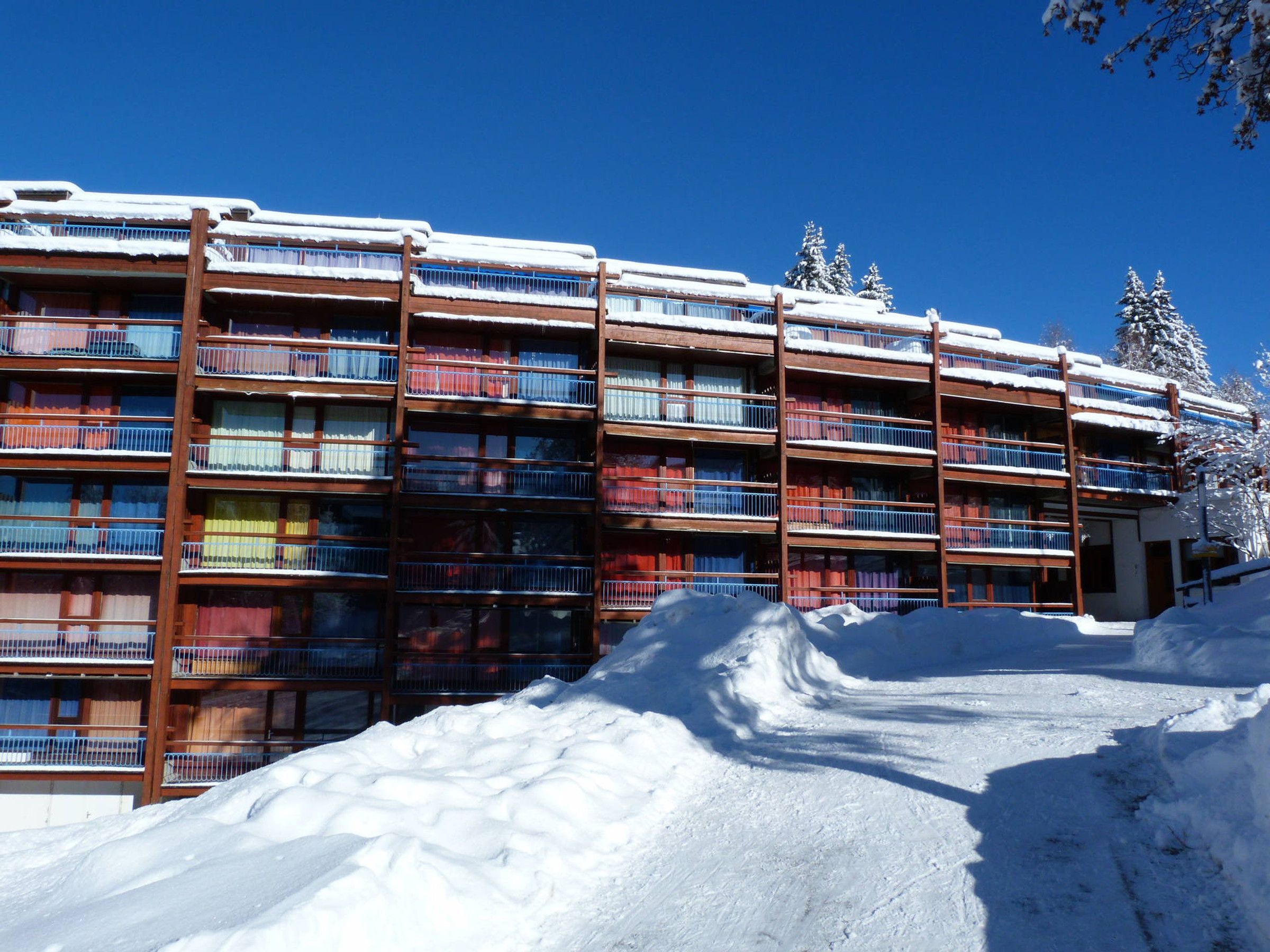 A multi-story hotel with balconies, surrounded by snow.
