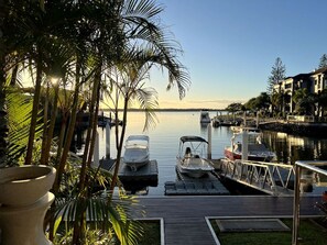 A marina with boats docked, a wooden dock, and a clear sky. - Waterfront Oasis in Runaway Bay (Runaway Bay)
