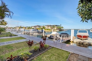 Un port de plaisance avec des bateaux amarrés, une promenade en bois et un ciel dégagé.