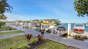 Un port de plaisance avec des bateaux amarrés, une passerelle en bois et un bâtiment en arrière-plan.