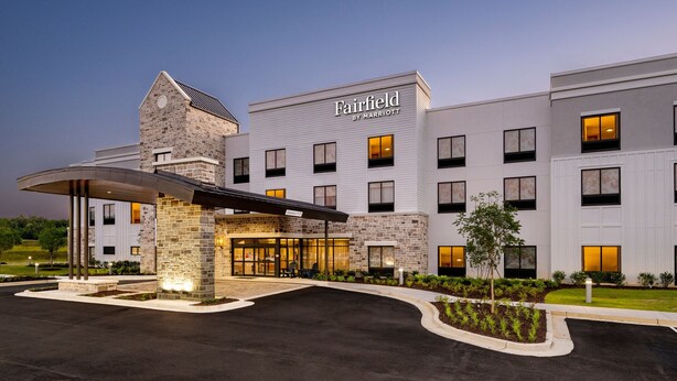 A Fairfield by Marriott hotel with a modern design, featuring a stone facade, multiple windows, and a covered entrance area.