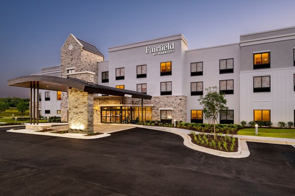A Fairfield by Marriott hotel with a modern design, featuring a stone facade, multiple windows, and a covered entrance area.