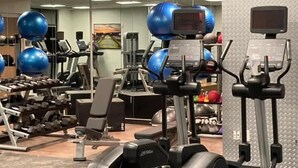 A gym with various exercise equipment including treadmills, elliptical machines, and weight machines.
