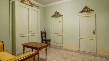 A room with two doors, a wooden table, a chair, and a radiator.