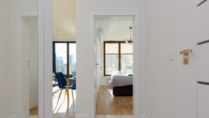 A modern bedroom with a large window, a bed, and a desk with a chair.