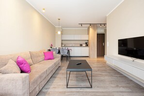 A modern living room with a sofa, coffee table, and TV.