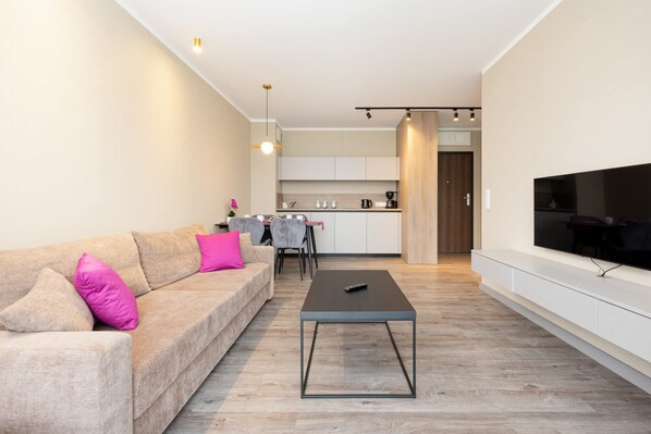 En moderne stue med sofa, sofabord og fjernsyn.