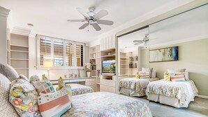 A bedroom with two beds, a large window with blinds, a ceiling fan, and a bookshelf. - Unbeatable Ocean Vistas at Polo Beach Club #606 – Beachfront Living in Wailea (Makena, Maui)