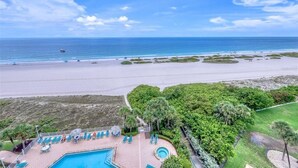 Un resort con zona de piscina, acceso a la playa y exuberante vegetación.