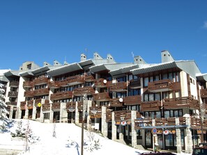 Guests can enjoy stunning views from the large windows and balconies with wooden railings.