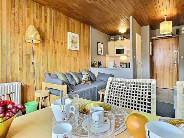 Relax in comfort with a sofa, wicker chair, and kitchenette, perfect for a casual meal or quiet time.