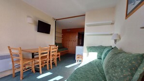 A compact room with a bed, a small table, and chairs. - Ski-in studio, pets allowed, Arc 1800 (Les Arcs 1800)