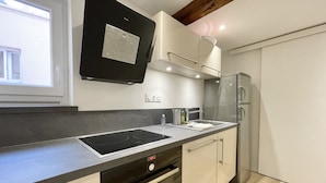 Uma cozinha moderna com fogão, forno e geladeira embutidos.