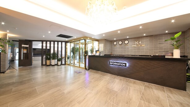A hotel reception area with a modern design, featuring a reception desk, a chandelier, and potted plants. - Hotel Stay Gumi (Gumi)