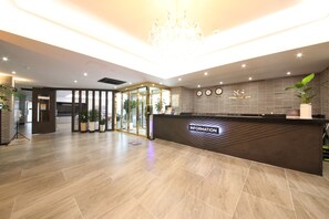 A hotel reception area with a modern design, featuring a reception desk, a chandelier, and potted plants. - Hotel Stay Gumi (Gumi)