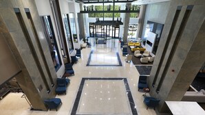 A spacious lobby with a central seating area, a fireplace, and a view of the outdoors. - Park Dedeman Adıyaman (Adiyaman)