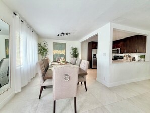 A modern kitchen with dark cabinets, a stainless steel refrigerator, and a microwave.