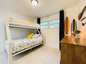 A bunk bed room with a desk and surfboards on the wall. - Beach House-Game room-Downtown-Heated Pool-HotTub (Fort Lauderdale)