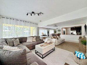 A modern living room with a sectional sofa, a coffee table, and a dining area. - Beach House-Game room-Downtown-Heated Pool-HotTub (Fort Lauderdale)
