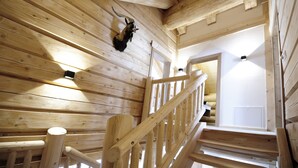 A wooden interior with a staircase, wooden beams, and a mounted animal head. - Yellowstone by Summit Lodges (Pfunds)