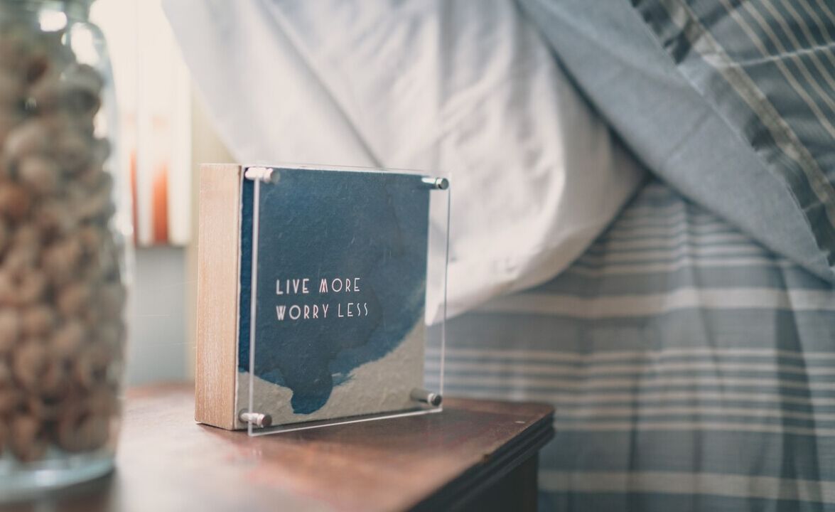 A wooden box with the text "LIVE MORE WORRY LESS" on a table.