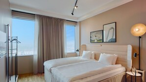 A modern hotel room with a large bed, a city view, and a window with curtains. - Scandic Örebro Central (Örebro)
