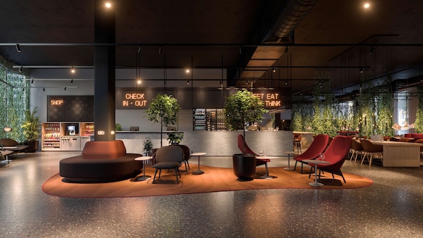 A modern interior with seating areas, a counter with a neon sign, and indoor plants. - Scandic Örebro Central (Örebro)