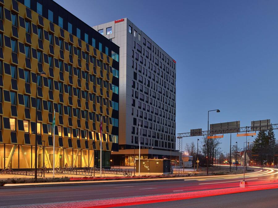 A modern hotel with a distinctive geometric facade, multiple floors, and a prominent signage.
