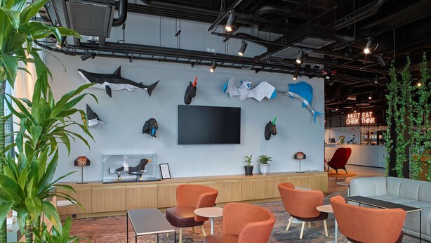 A modern lounge area with seating, a large flat-screen TV, and various wall decorations including shark and whale figures. - Scandic Örebro Central (Örebro)
