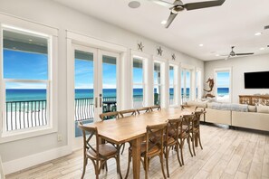 Relax in this spacious living area with a large dining table and comfortable seating for six, offering stunning ocean views.