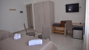 A hotel room with a bed, a desk, a television, and a wardrobe. - Triple room in the center of Catania (Catania)