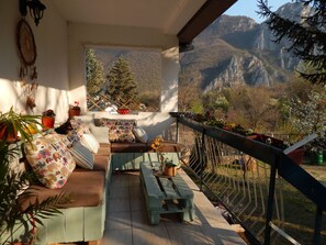 A balcony with a sofa, cushions, and potted plants. - Impeccable Apartment With View in Dolna Matka (Matka)