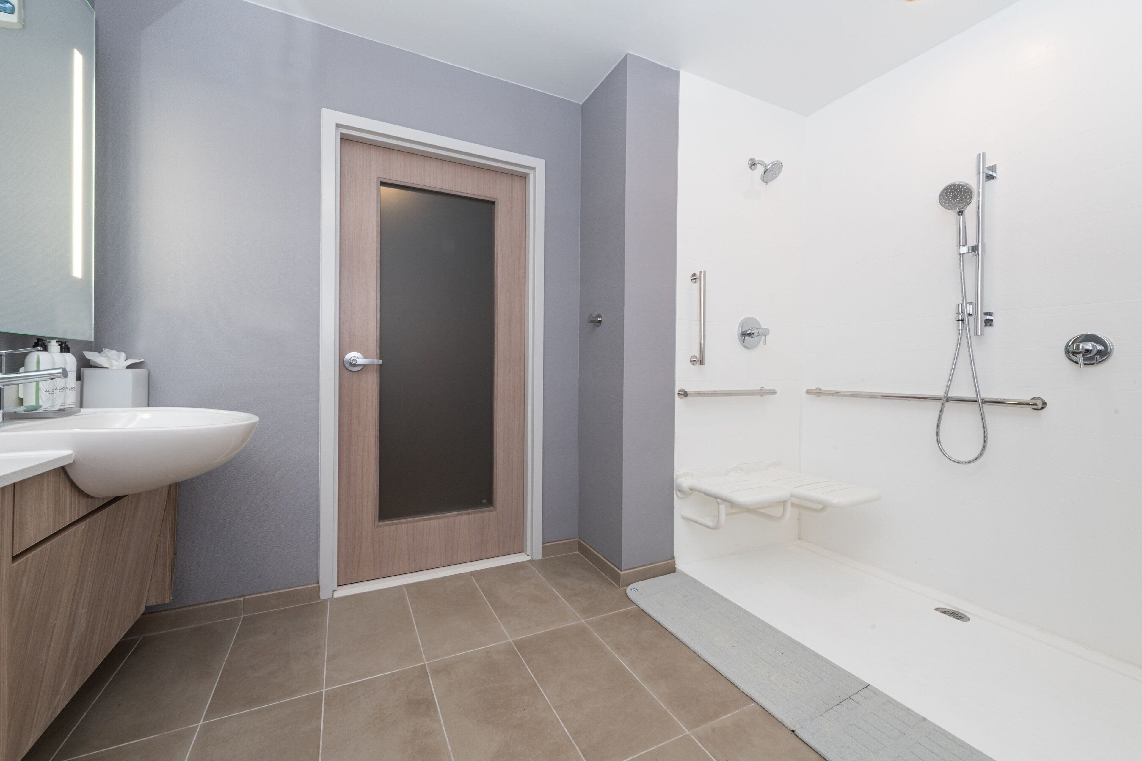 A modern bathroom with a sink, mirror, and shower.