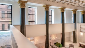 Eine großzügige Lobby mit hohen Decken, großen Fenstern und klassischen Säulen.
