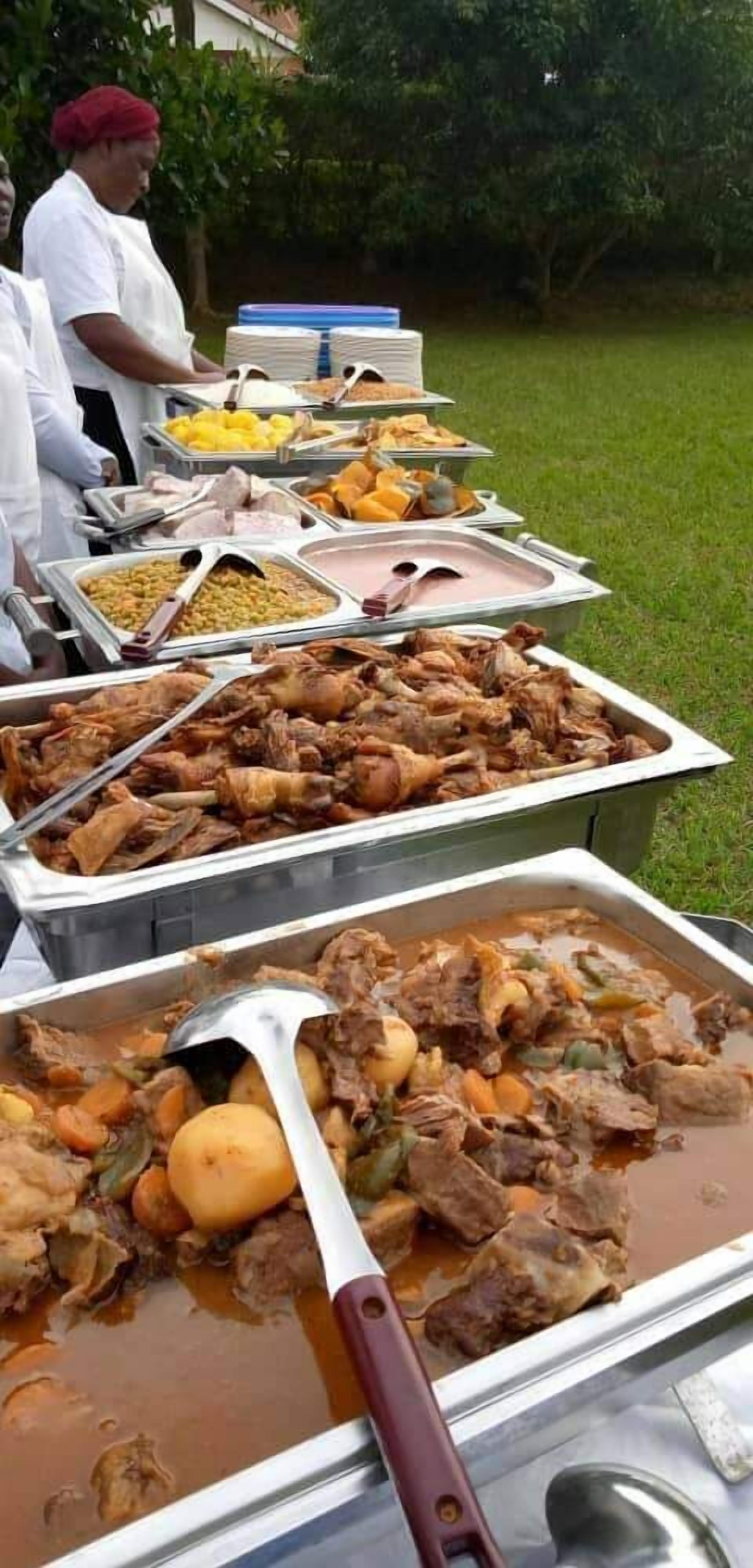 Un bufé con una variedad de platos, incluyendo carnes, verduras y postres.