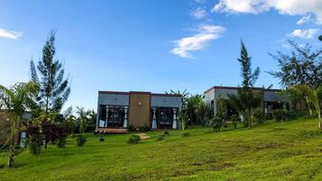 A modern two-story house with a flat roof, large windows, and a well-maintained lawn.