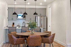 Una cocina moderna con armarios grises, electrodomésticos de acero inoxidable y una isla central con un florero.