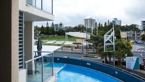 A pool area with a view of the cityscape, including buildings and greenery. - Tides & Tranquility - 2Bedroom Kings Beach Unit (Kings Beach)