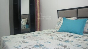 Un dormitorio con cama, armario y espejo.