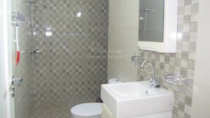 Un baño con ducha, inodoro y lavabo.